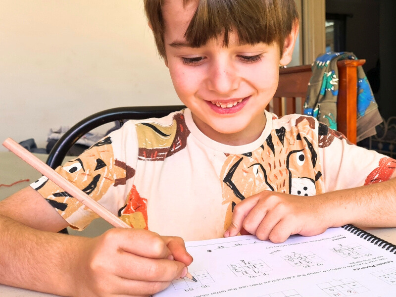 milestone maths Australia homeschool friendly maths program Image of young boy working on maths problems