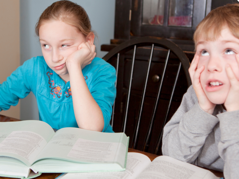 Common Reasons Kids Avoid Writing and How To Help Image of 2 children not wanting to do any writing