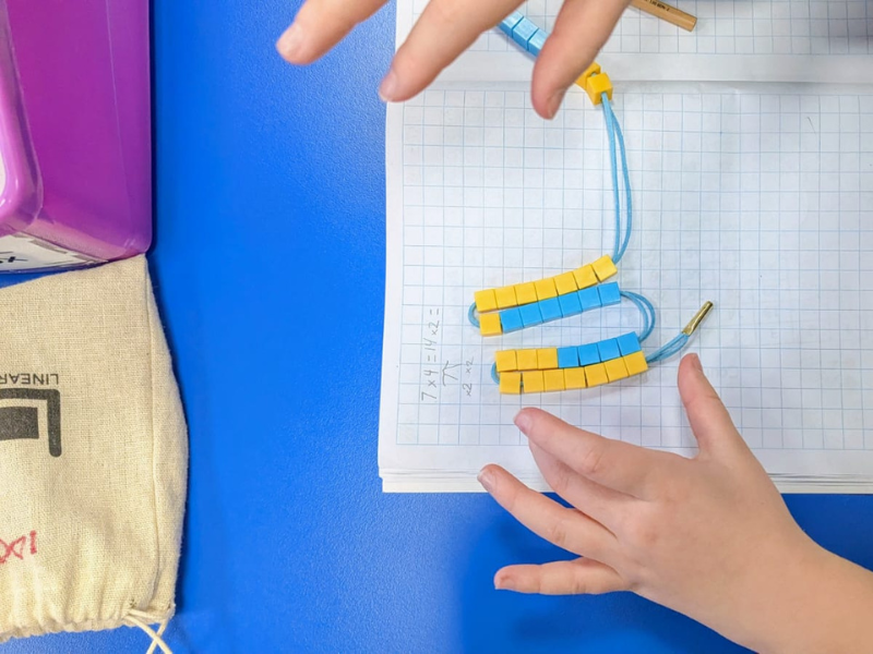 Homeschooling child using the linear abacus for their hands on maths lessons