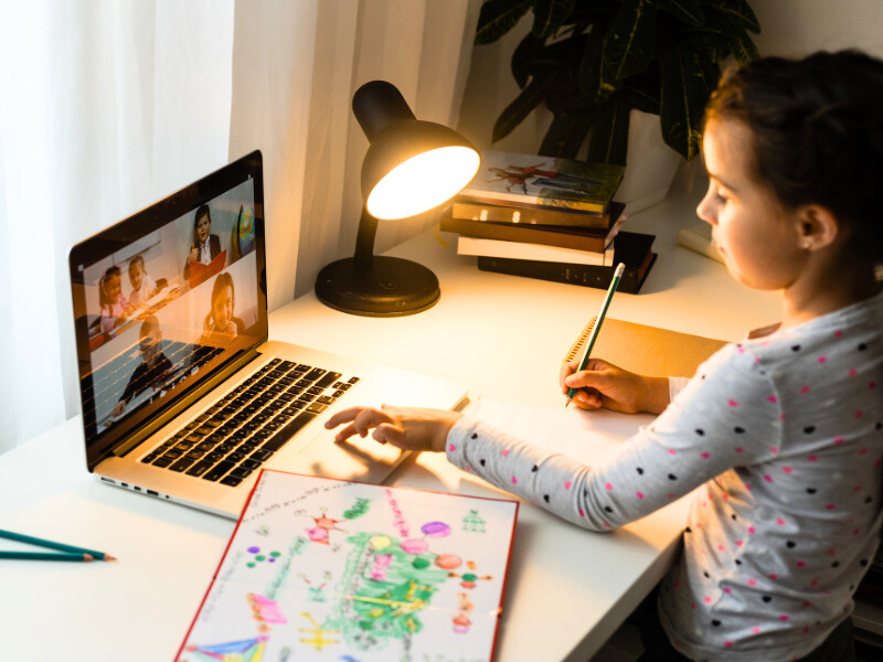 Image of child sitting at desk with her laptop taking a class with Modern Waldorf online holistic homeschool classes