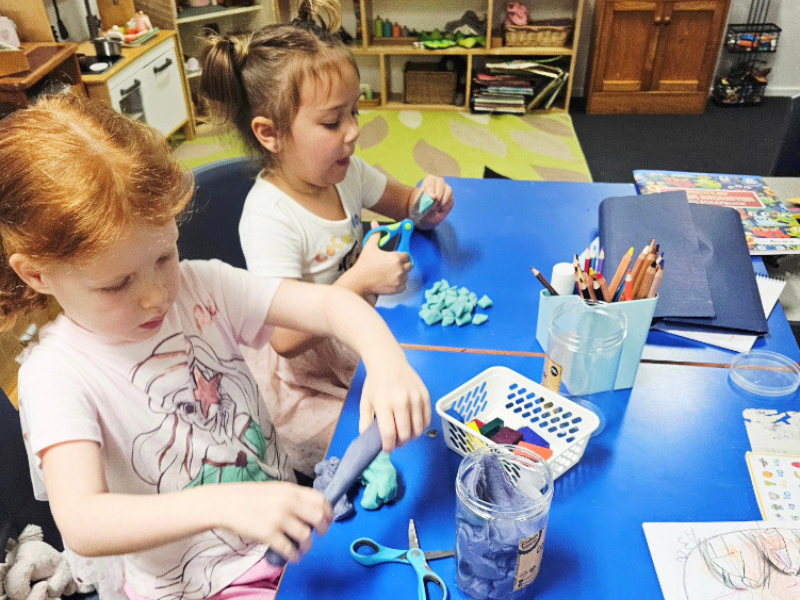 waldorf main lesson with children using playdough and scissors
